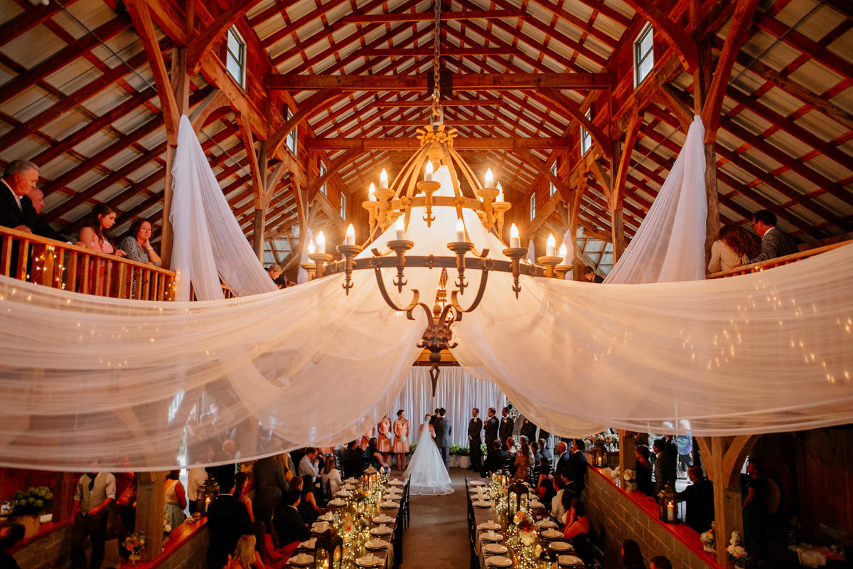 beautiful indoor wedding ceremony in barn by the oberports