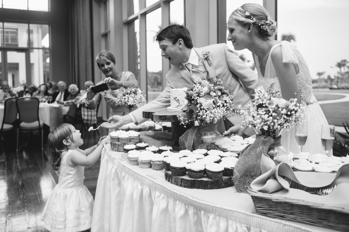 groom feeds flowergirl wedding cake