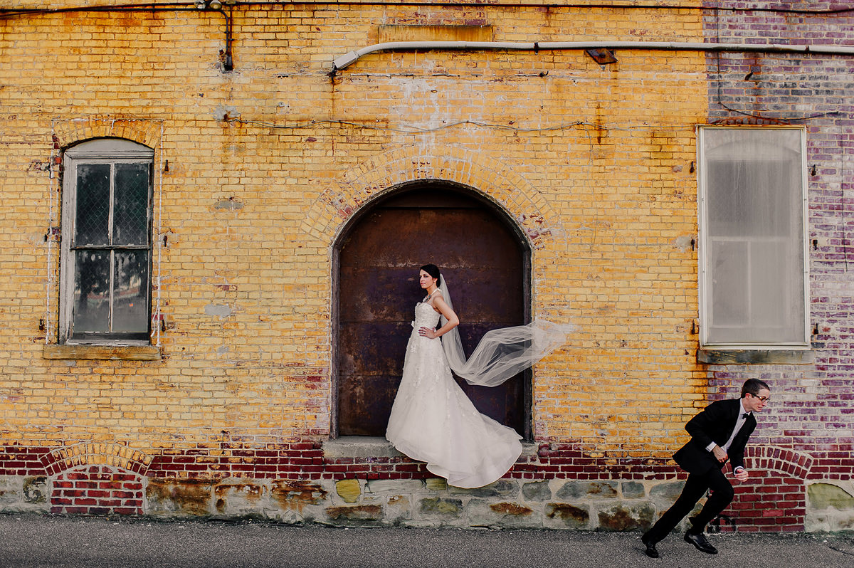 creative bride and groom portrait with groom running