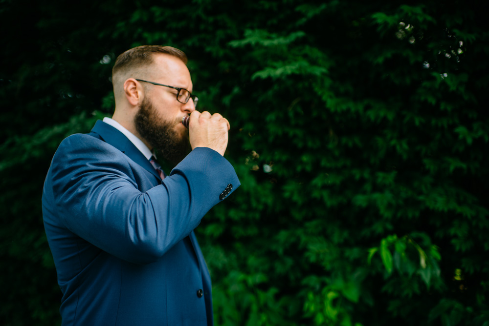 groom sips from a flask before first look