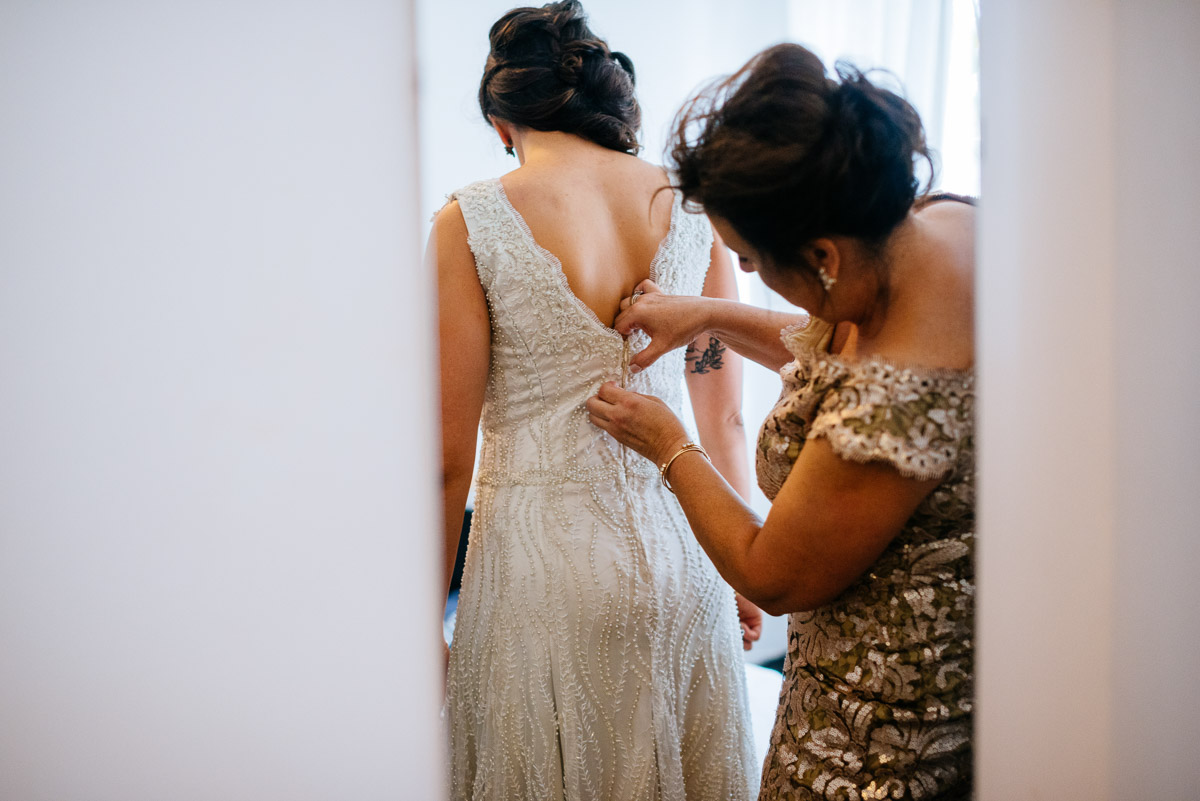 mom sewing bride into dress