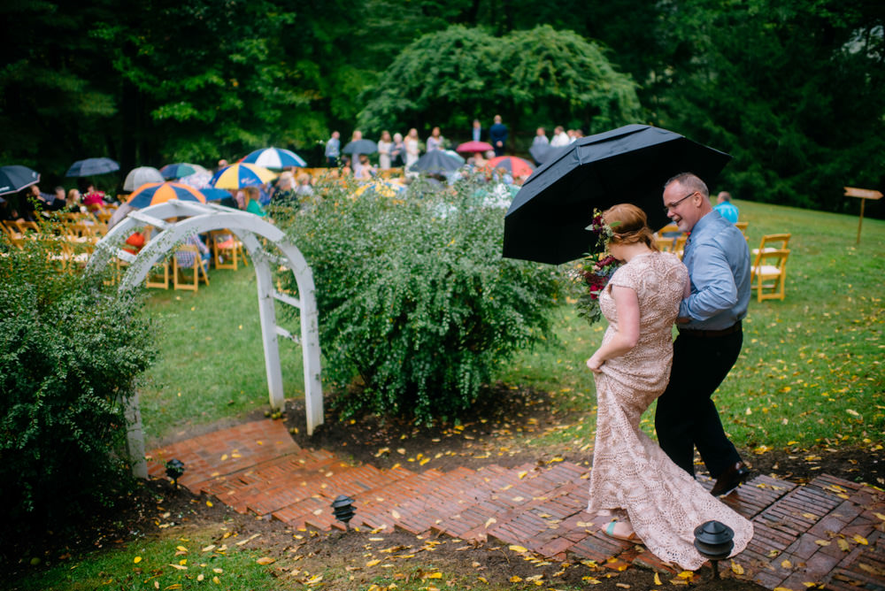 bride and father walking down aislewith umbrella wedding ceremony benedict haid by the oberports