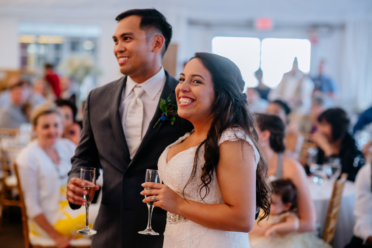 bride and groom enjoy speeches at wedding reception