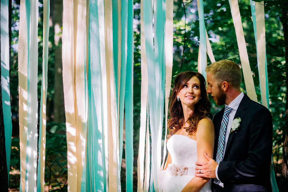 bride and groom with streamers in the woods