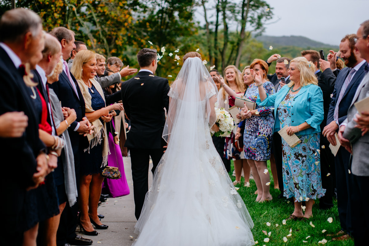 guests throwing flower petals at bride and groom as they leave the church