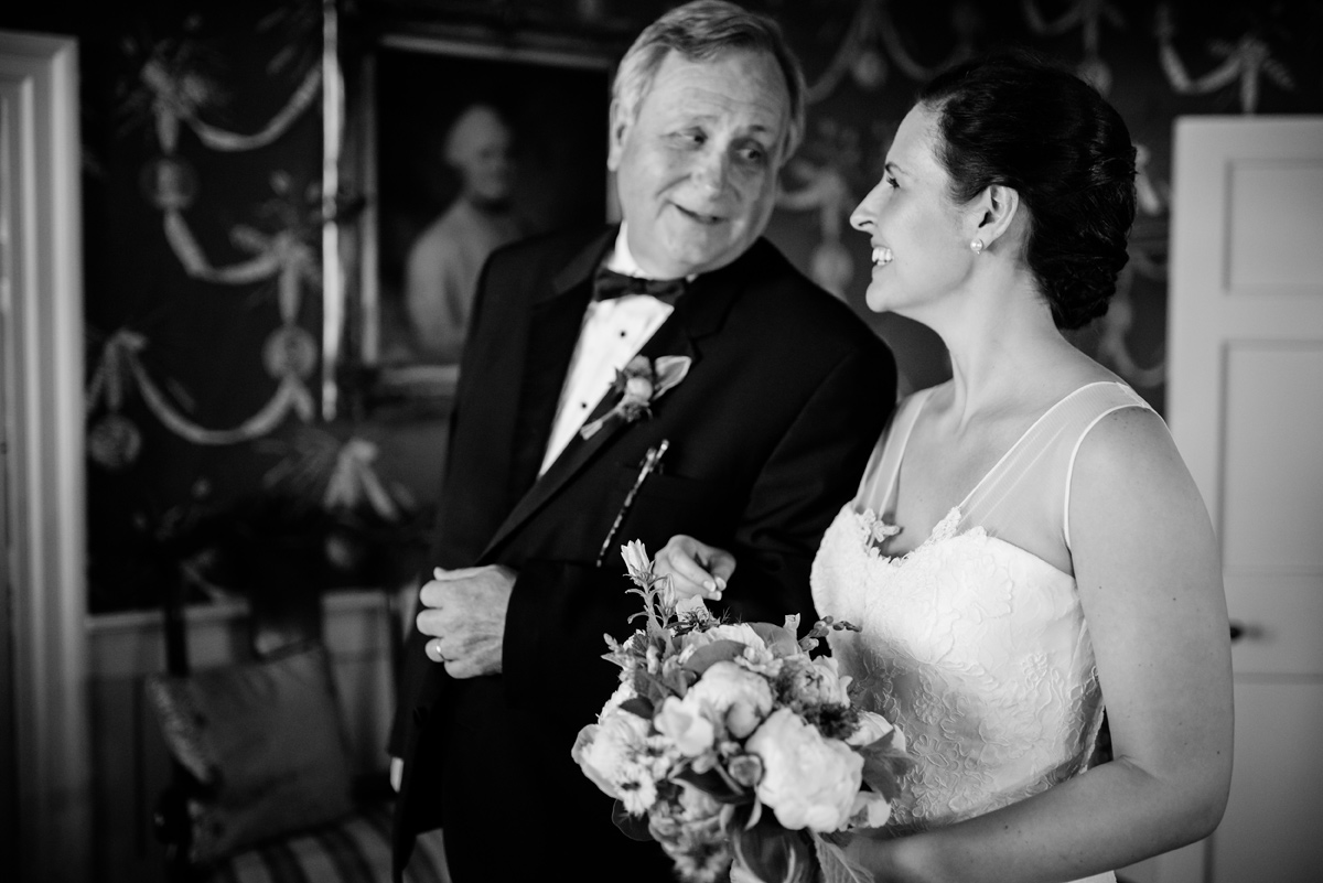 bride and father laugh before walking down aisle