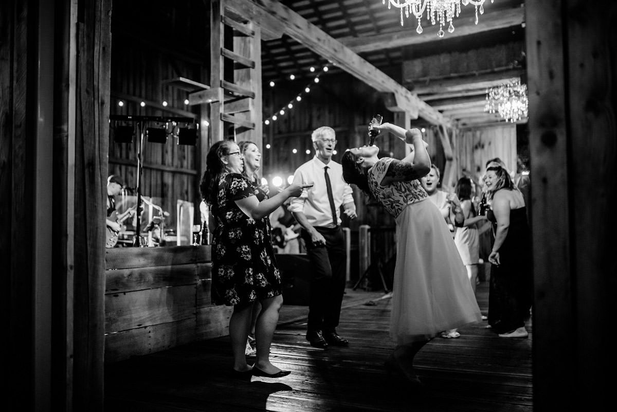 bride chugging beer at wedding reception