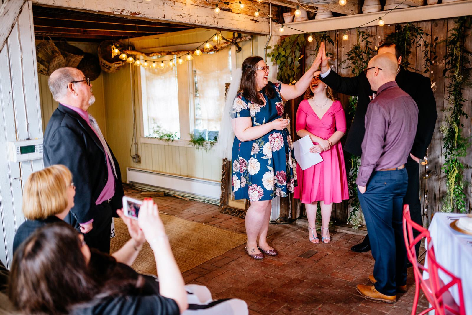 bride high fives officiant brother during ceremony in mushroom house terrain elopement