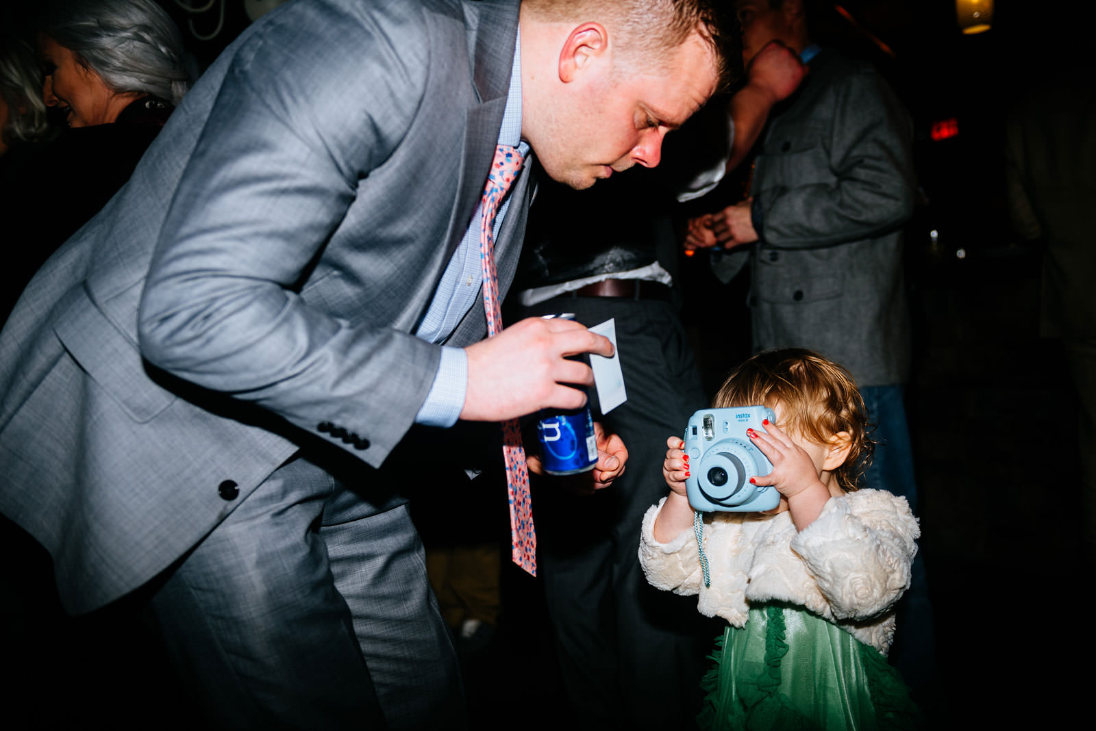 kid using instax camera at wedding reception