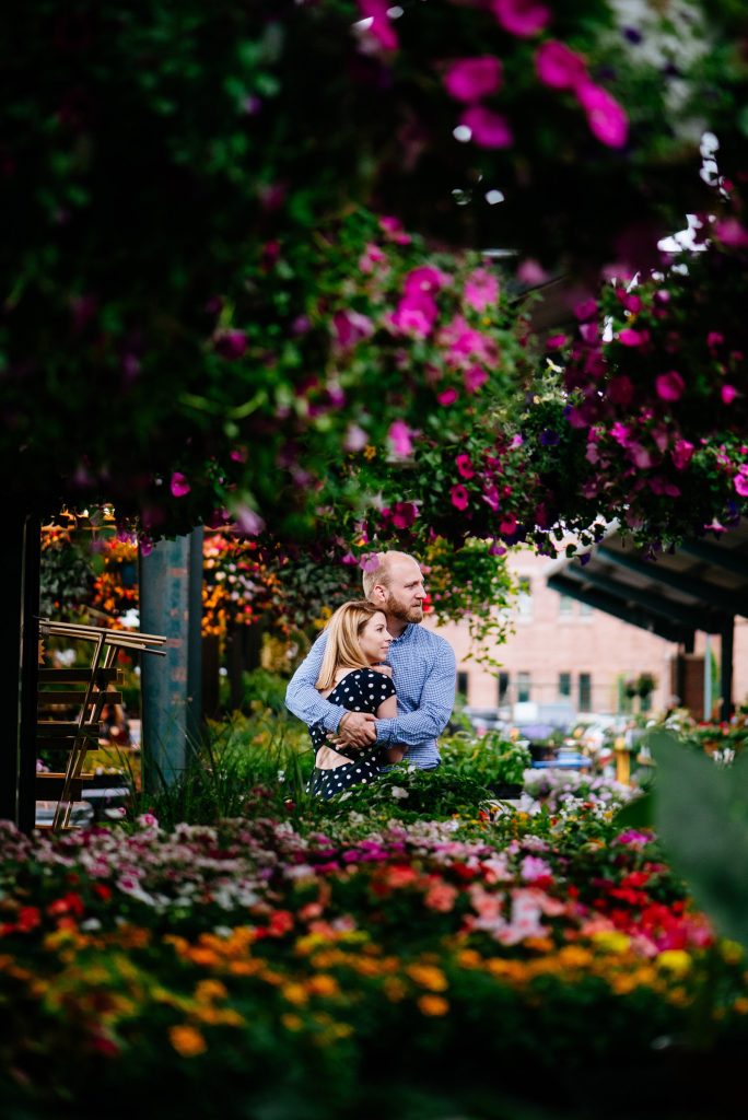 Couple hugging amongst the flowers at Capitol Market.