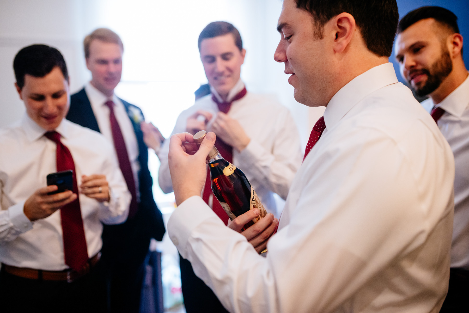 groom opening bottle of pappy whiskey