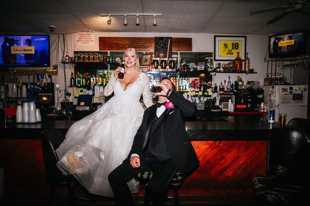 bride and groom drinking on bar at red carpet