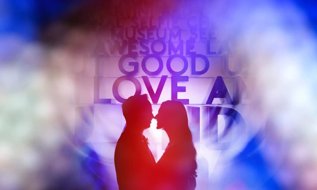 A silhouette of a couple kissing is blended with a creative overlay of positive words like "LOVE" and "AWESOME" in various sizes and a bold color gradient.