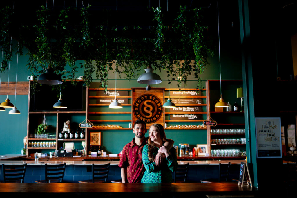 Aaron and Alyssa laughing during their engagement session at the Short Story Taproom in Charleston WV.