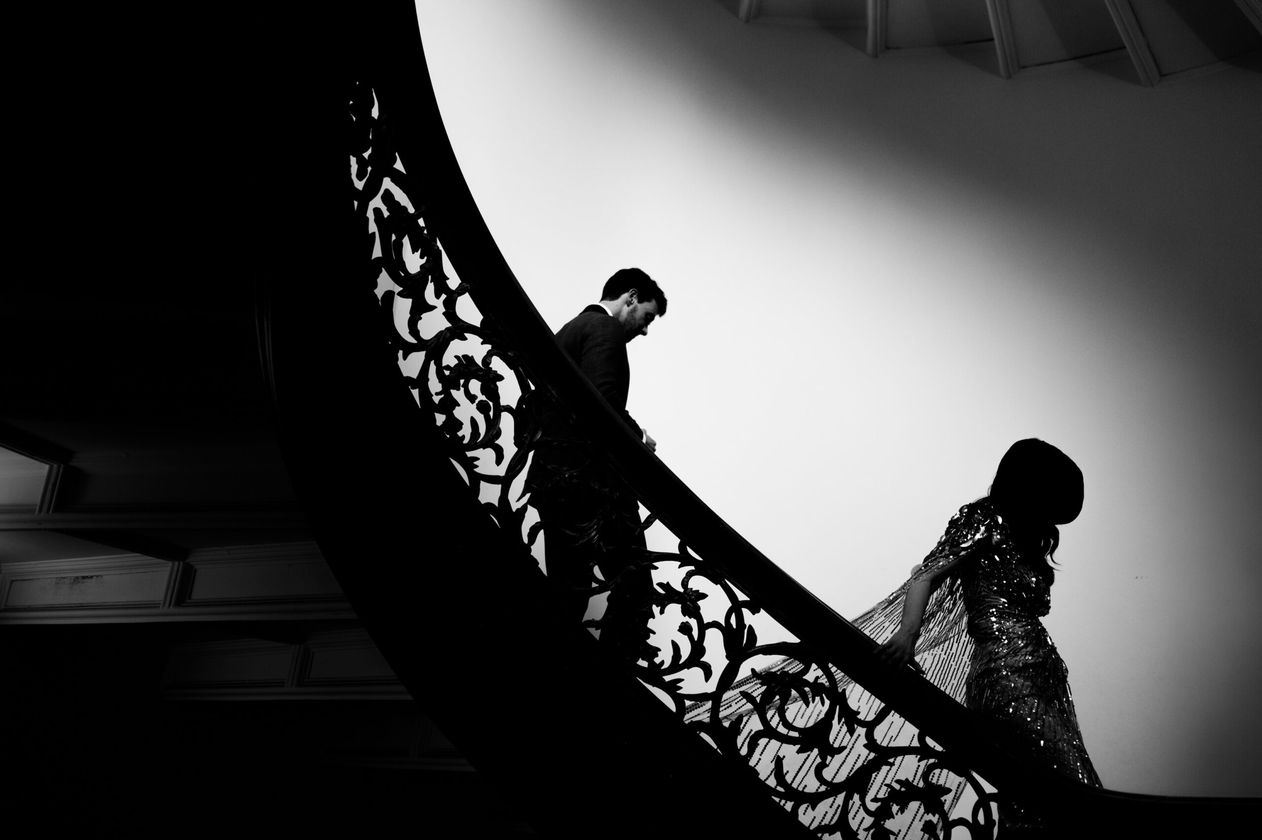 A striking silhouette of a man and a woman ascending a staircase.