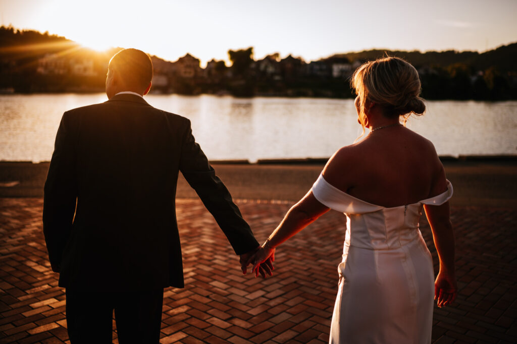 Carlie and Chrstopher hold hands and walk along the waterfront in Wheeling.