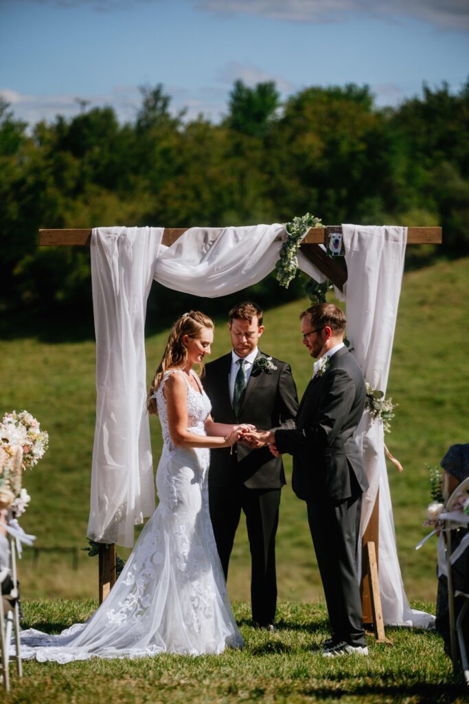 bride and groom exchange rings at batten green wedding