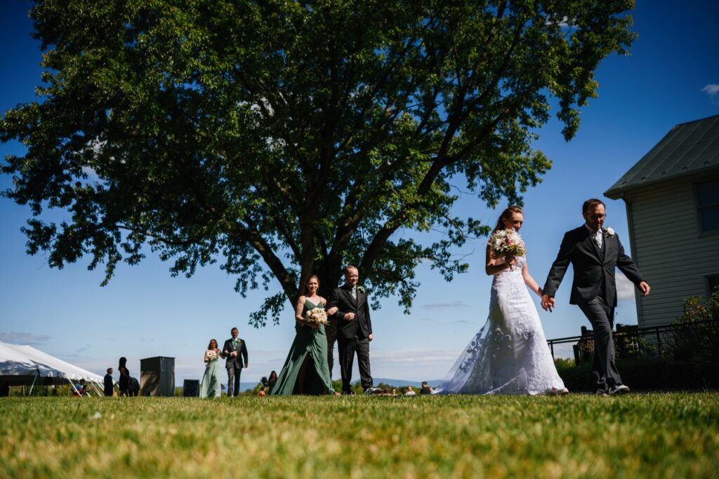 bride and groom and wedding party exit ceremony at batten green wedding venue