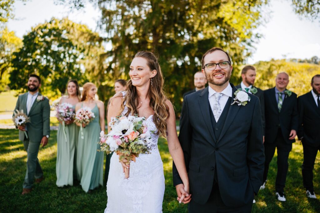 bride and groom walking and laughing with wedding party