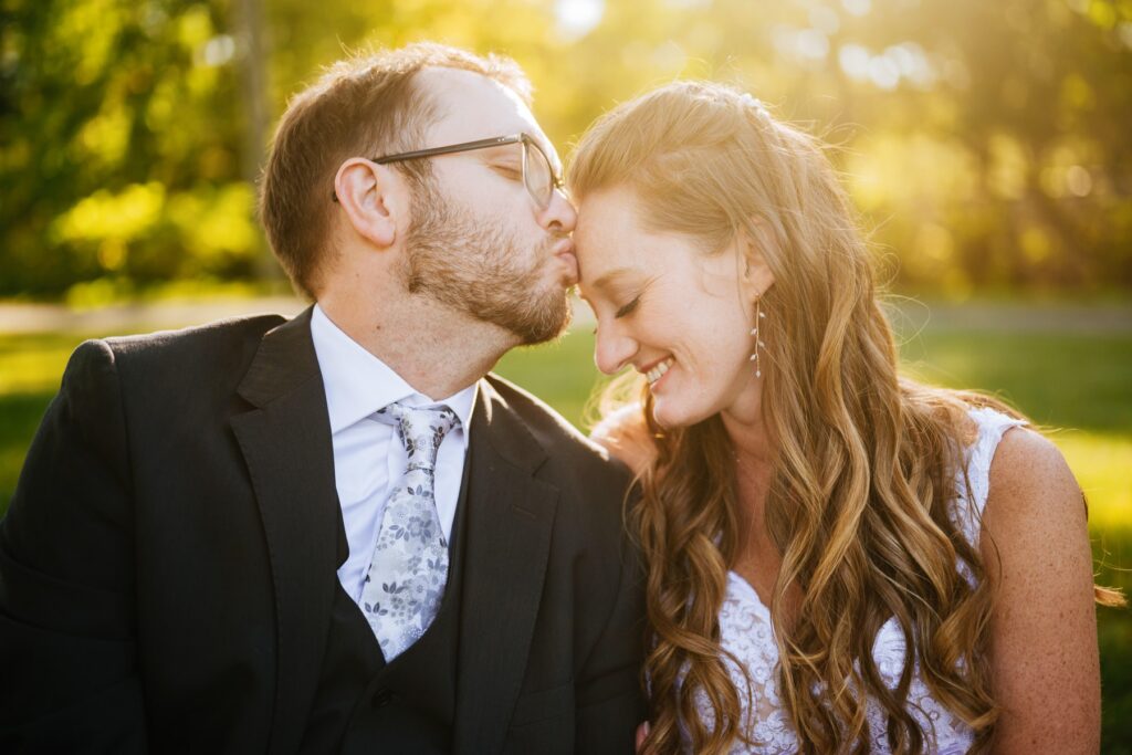 groom kissing bride on forehead