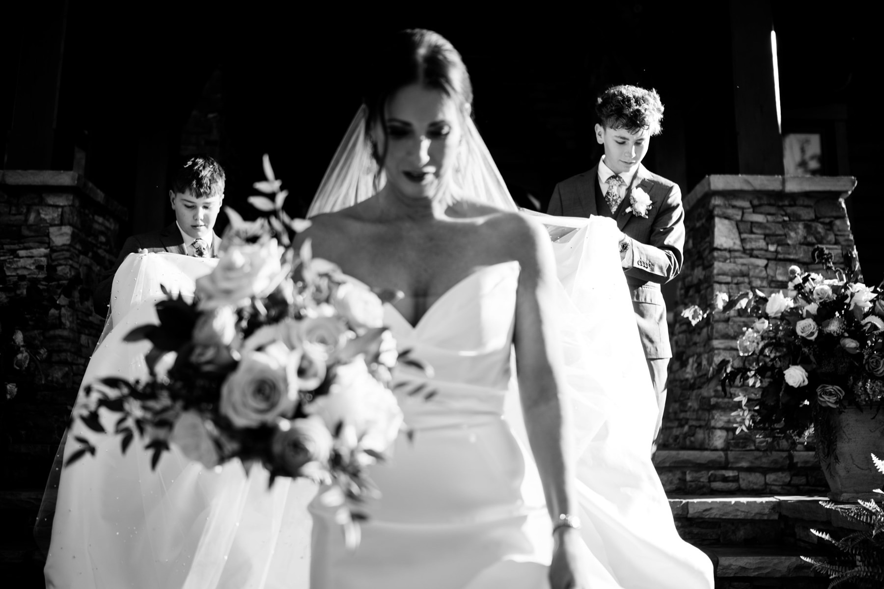 Bride's sons helping her walk down the aisle at her Wilderness Lodge Summersville WV wedding.