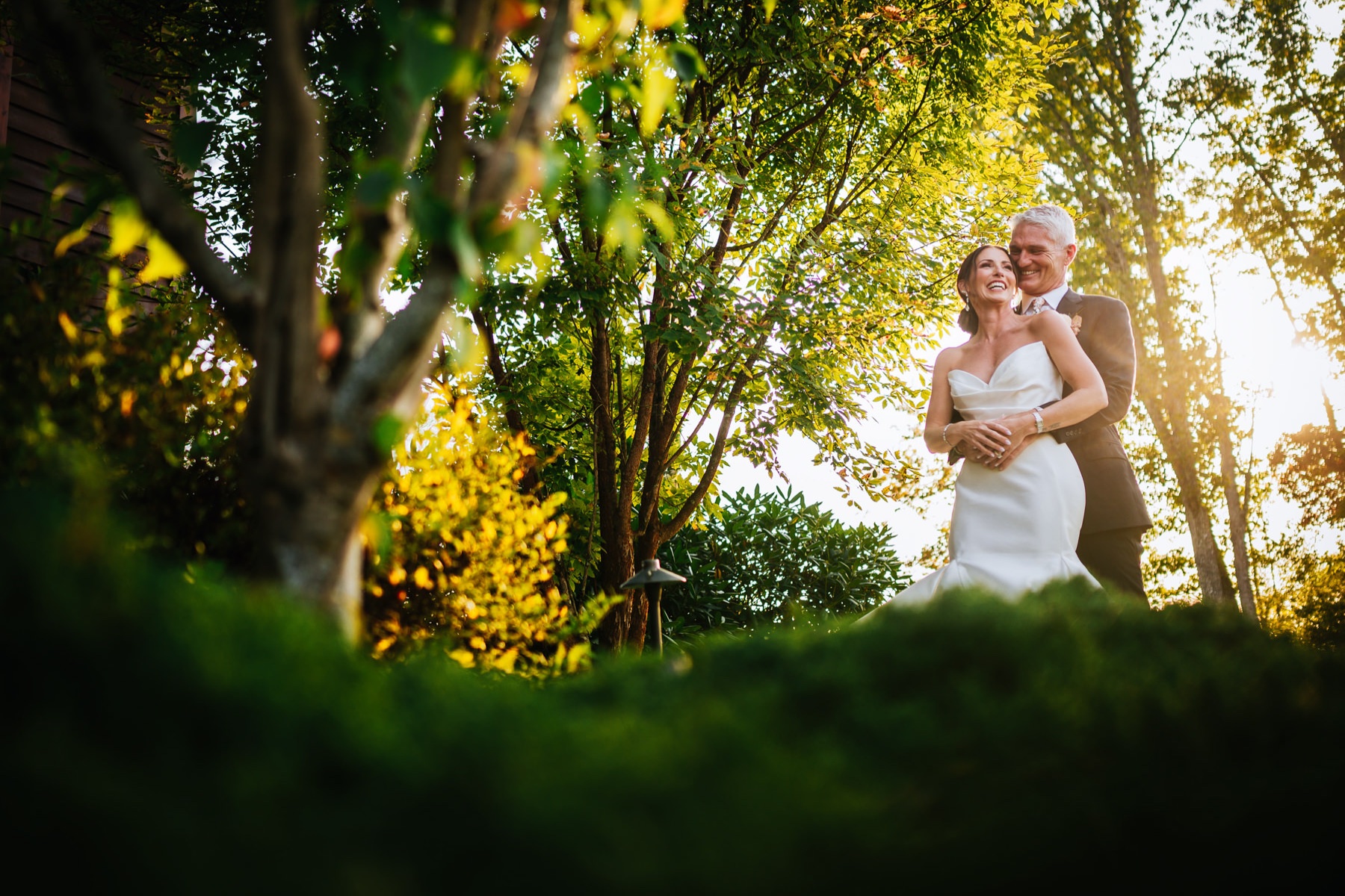 Kevin and Melissa cuddling amongst the greenery at their Wilderness Lodge Summersville WV wedding.