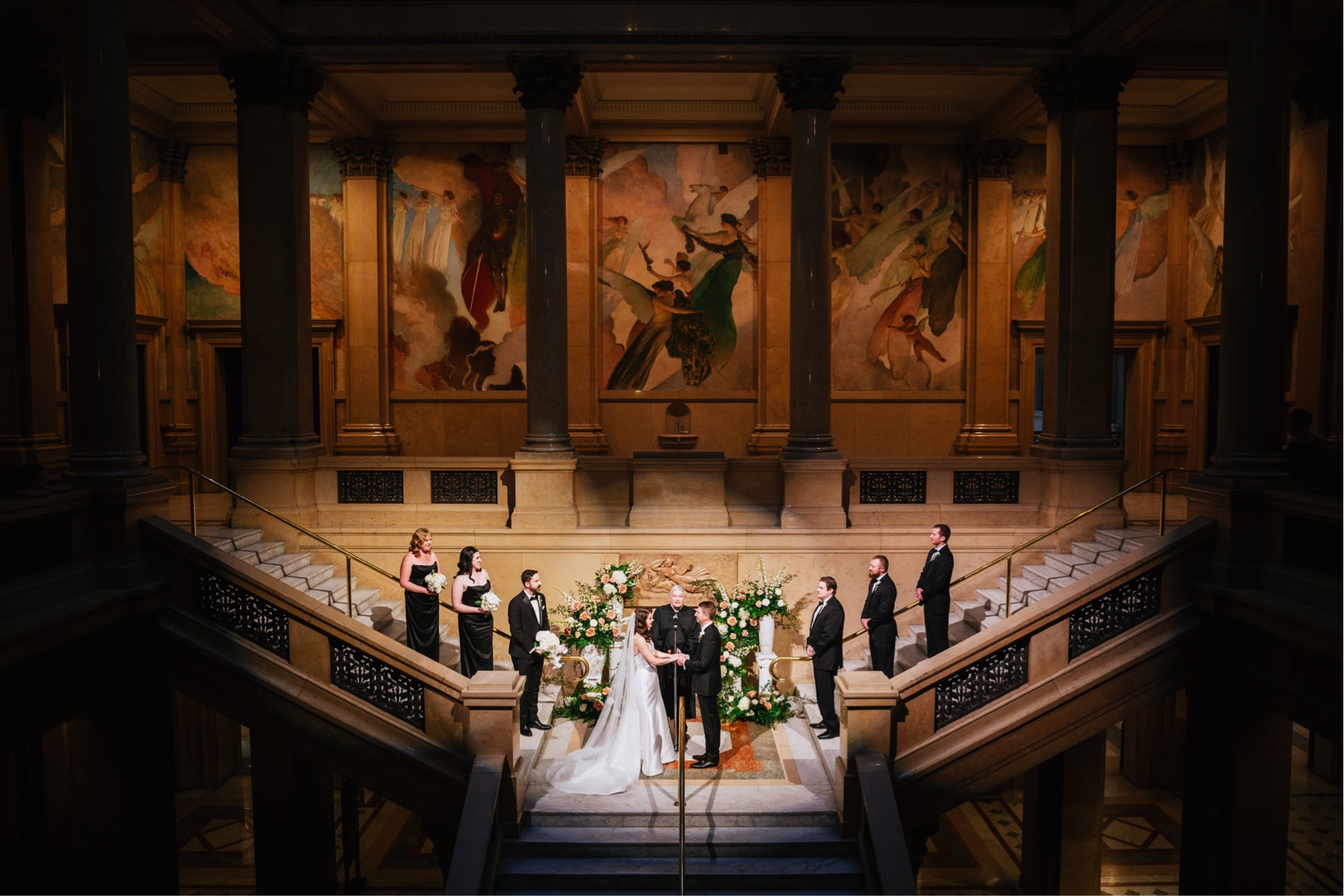 Bride and groom exchange vows on the staircase at this Carnegie Museum of Natural History wedding.