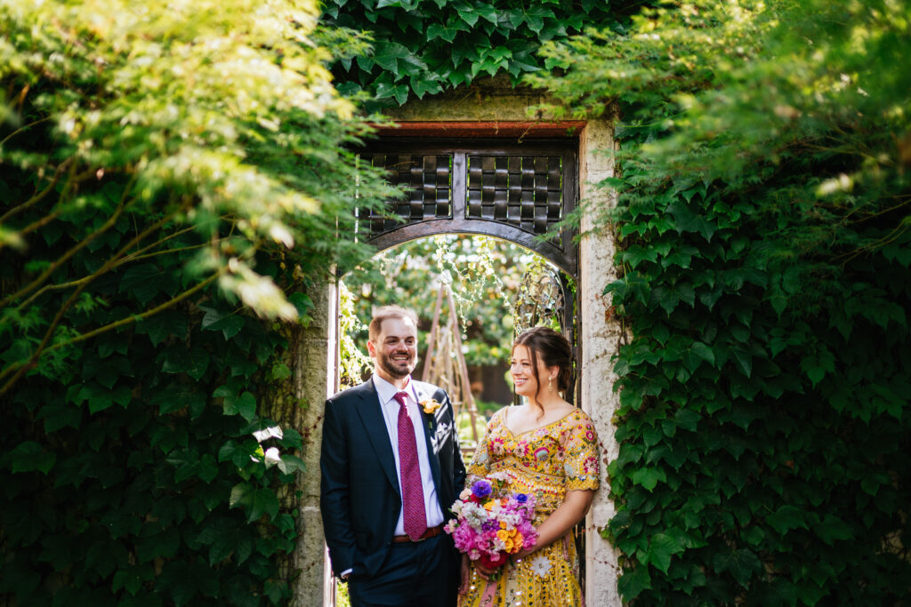 Bride and groom laughing while standing in the garden at their Apiary Lexington wedding.