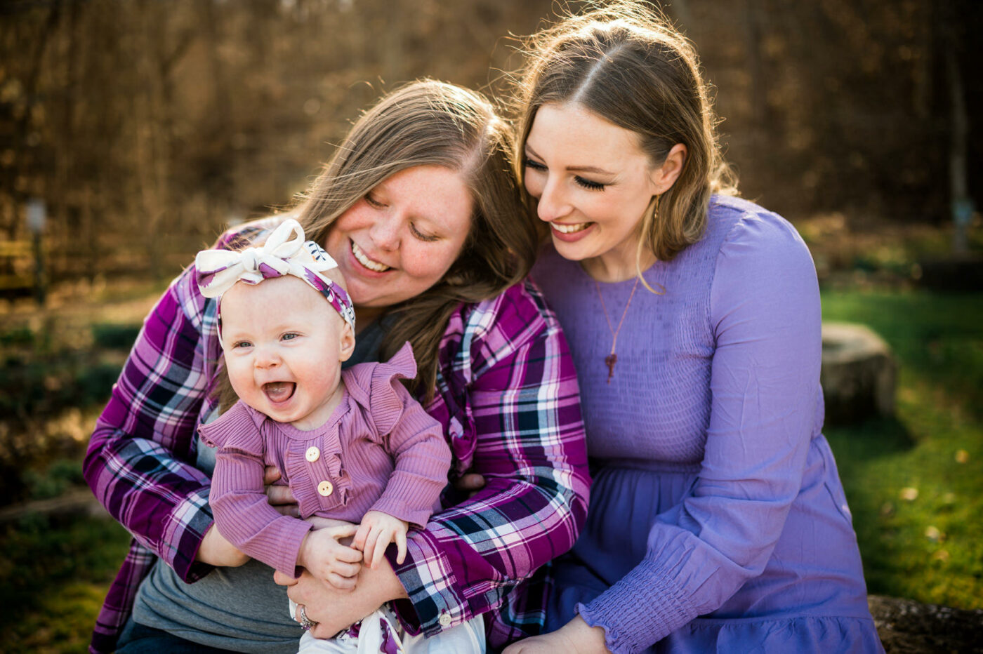 LGBTQ married couple laughing with their baby daughter at the Carriage Trail in Charleston, WV.