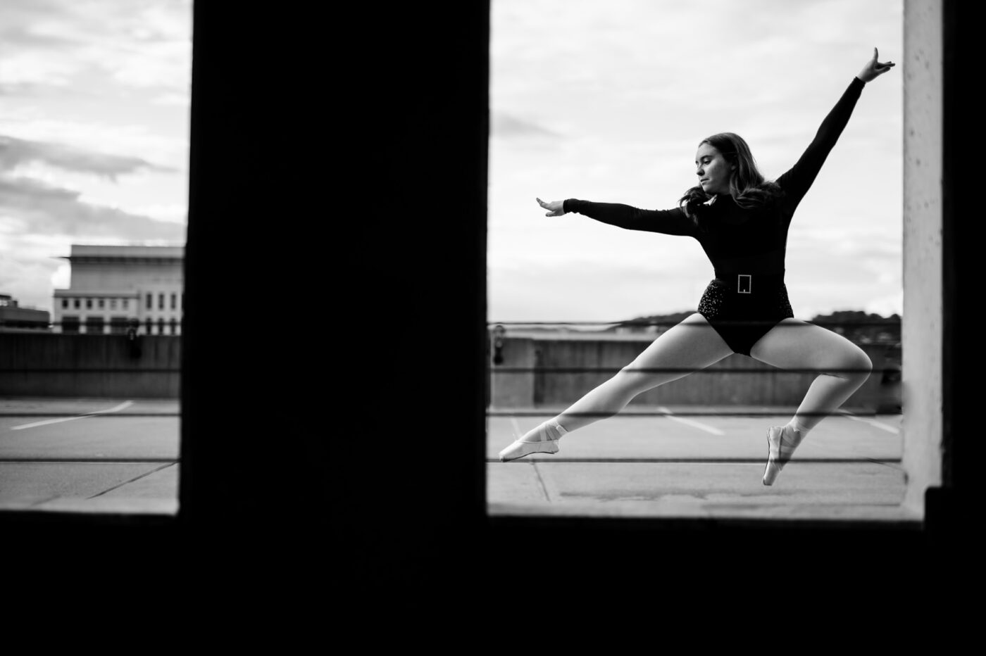 Lydia attempts a jump in her ballet attire during a portrait session in a Charleston parking garage. 