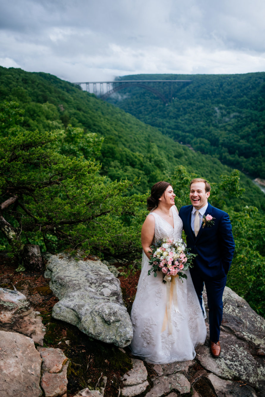 Just married bride and groom sharing a laugh while standing on an overlook at Adventures on the Gorge resort.