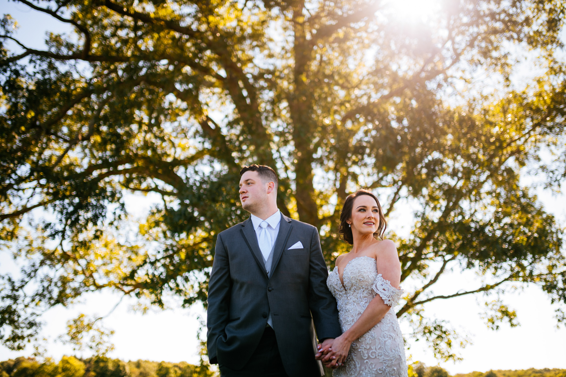 bride and groom in front of tree