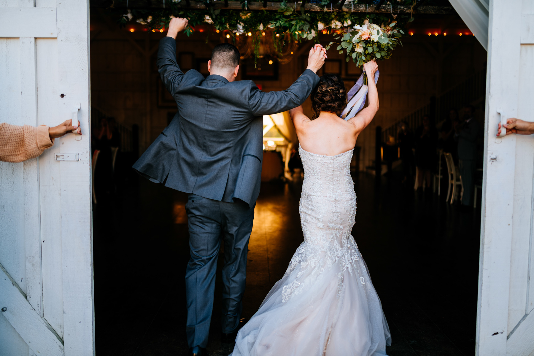 bride and groom enter reception white barn at lucas farm wedding