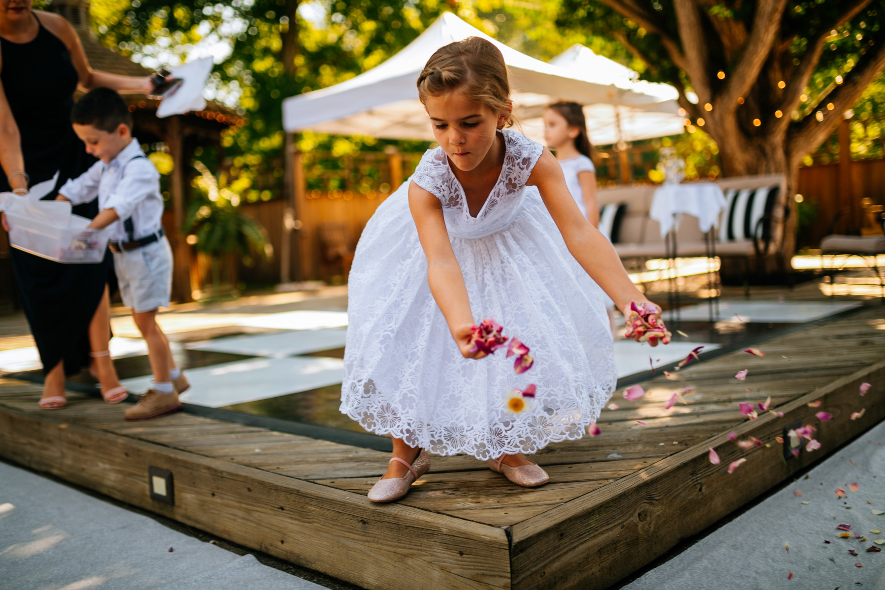 little girl spreads flowers before wv backyard minimony