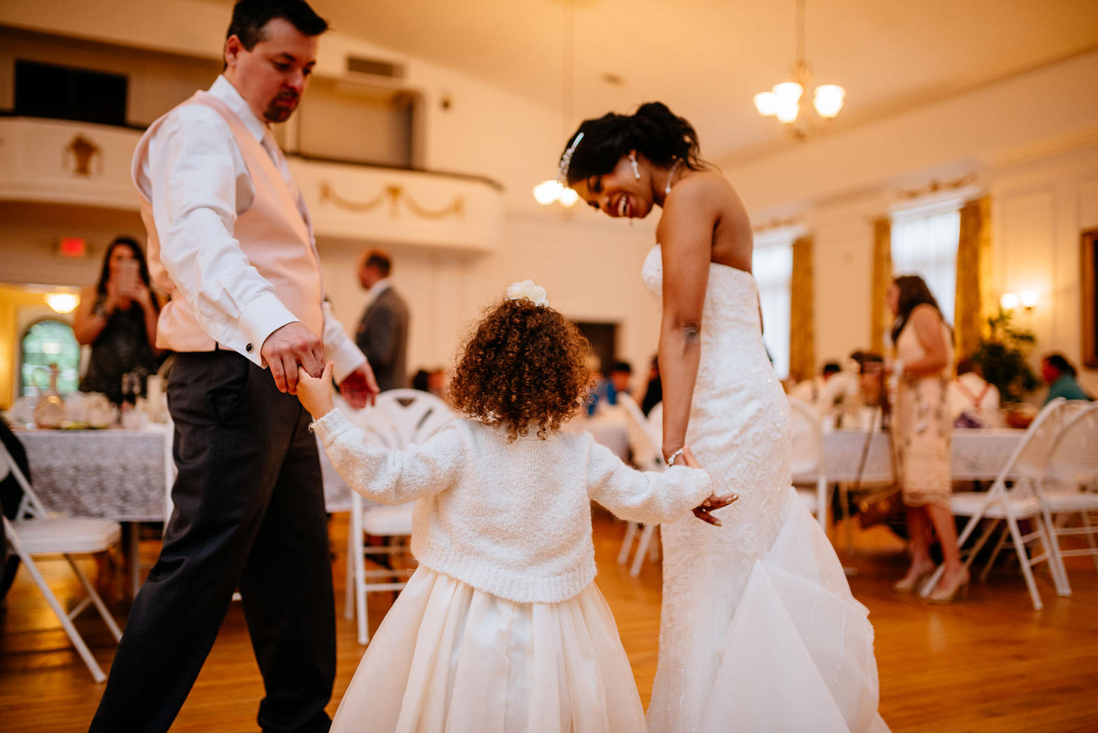 bride and groom dancing with flower girl